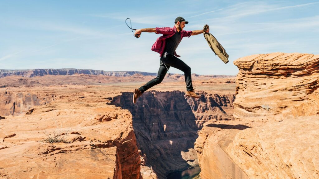 man jumping on rock formation